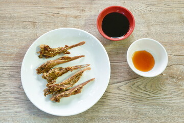 deep fried duck beak with white sesame dipping chili and black sweet soy sauce on plate