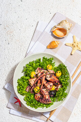 Octopus salad with lettuce, olives and spices in a bowl. Fresh and healthy seafood, marine decor
