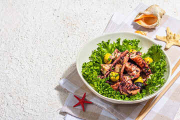 Octopus salad with lettuce, olives and spices in a bowl. Fresh and healthy seafood, marine decor