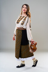 Woman in Romanian traditional costume on gray