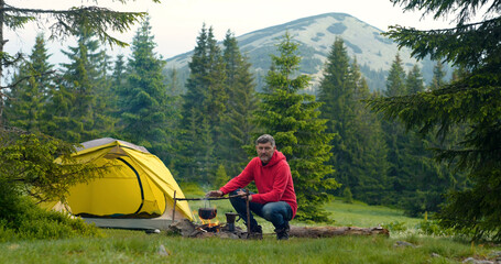 Fototapeta premium Bearded man near a fire in the mountains
