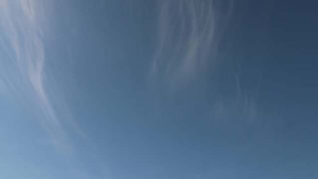 4K timelapse of light as feathers cirrus clouds moving in light blue sky