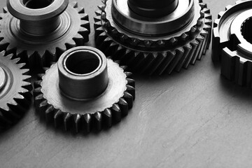 Different stainless steel gears on grey background, closeup