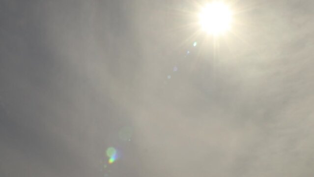 Flat altostratus clouds tinted orange 4K timelapse with sun shining through