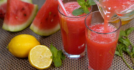 Watermelon banana orange Smoothie is poured into a glass on the background of fresh fruits