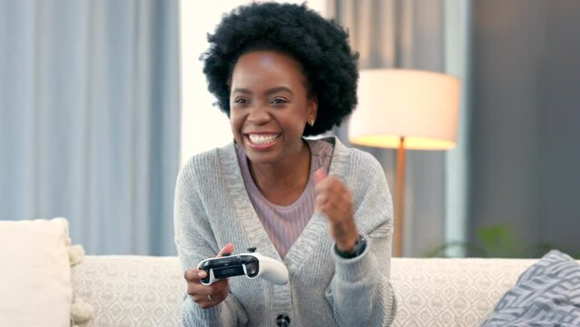 Excited female gamer cheering after winning an online video game. Young woman playing a multiplayer game and finishing or completing a checkpoint. Celebrating with a fist pump and happy expression