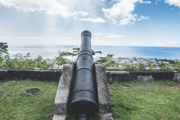 Old vintage black iron cannon facing Atlantic Ocean in the Capital of Dominica, Roseau