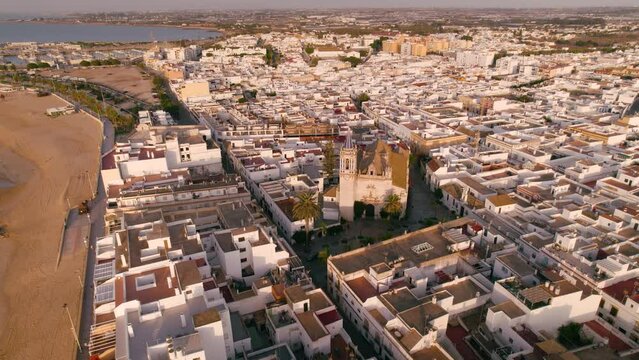 Sky view of the city Chipiona flying a drone, in the province of Cadiz (Andalucia, Spain). In the shot is shown the cathedral 'Nuestra senora de la O', and typical andalusian small white houses.