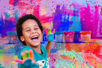 beautiful happy boy with painted hands over a colorful painted background 