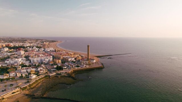 Sky view of the beautiful city Chipiona flying a drone, in the province of Cadiz (Andalucia, Spain). In the shot is shown Chipiona's lighthouse at the coast, and typical andalusian small white houses.