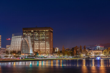 Obraz premium Downtown Oakland, Lake Merritt at night with water reflection.