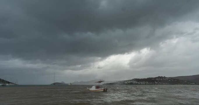 Fishing boat standing on the beach, rippling sea, dark clouds and the coming of the storm Bodrum, Bitez.