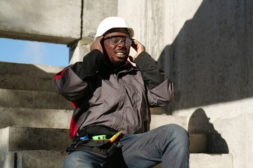 African american worker at project site has headache, he massages his head