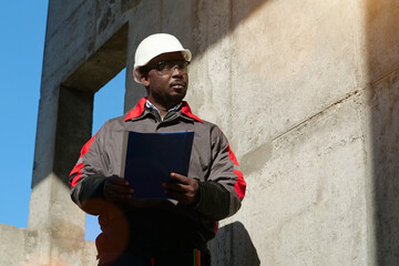 African american workman at construction site with work papers