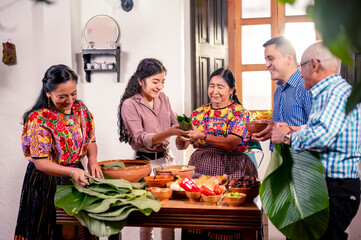 Familia cocinando Tamales, platillo tradicional Guatemalteco. La familia se divierte cocinando juntos en la cocina. 