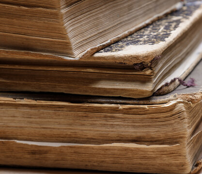 uneven corner of old books with brown textured paper and torn cover.vintage paper texture. selective focus. High quality photo
