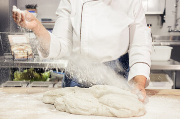 Kneading and preparation of sourdough-based bread. On a wooden table. in bakery