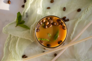 Cold coffee with milk and mint on a light background