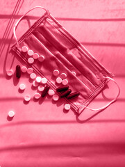 Vitamins and doctor s mask, corona virus protection concept on yellow background. Respiratory medical mask and pills. Fresh classic 2023 in blue. Color concept of the year.