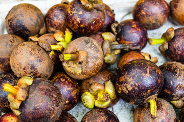 mangosteen fruits for sale at organic market in Asia. pile of mangosteen fruits (Garcinia mangostana)