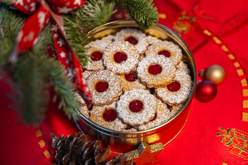 Spitzbuben oder Linzer Plätzchen in einer Blechdose mit weihnachtlicher Dekoration und einer roten...