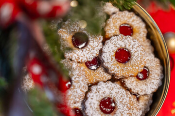 Spitzbuben oder Linzer Plätzchen in einer Blechdose mit weihnachtlicher Dekoration und einer roten...