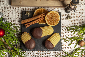 Fototapeta na wymiar Orange sticks, cookies on a slate with Christmas decorations
