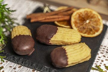 Orange sticks, cookies on a slate with Christmas decorations