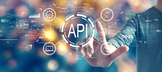 API - application programming interface concept with man on blurred blue city light background