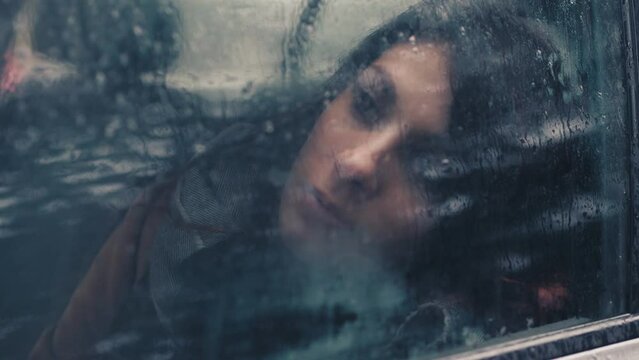 solitude, depression - woman with her head leaning against the car window thinks