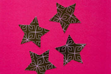 four paper stars on hot pink paper