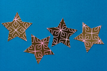 gold and pink patterned paper stars on blue