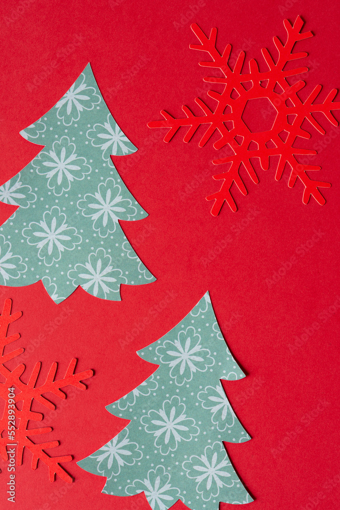 Wall mural red paper snowflakes and stylized paper holiday trees on red