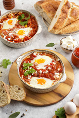 Traditional north african dish shakshouka made of eggs poached in a sauce of tomatoes, olive oil, bell peppers, onion and garlic, spiced with cumin, paprika and cayenne pepper