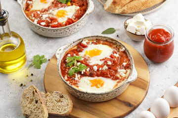 Traditional north african dish shakshouka made of eggs poached in a sauce of tomatoes, olive oil, bell peppers, onion and garlic, spiced with cumin, paprika and cayenne pepper