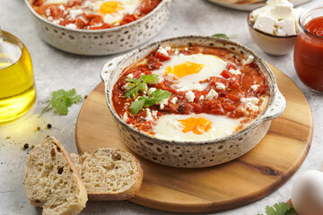 Traditional north african dish shakshouka made of eggs poached in a sauce of tomatoes, olive oil, bell peppers, onion and garlic, spiced with cumin, paprika and cayenne pepper