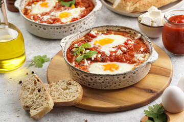 Traditional north african dish shakshouka made of eggs poached in a sauce of tomatoes, olive oil, bell peppers, onion and garlic, spiced with cumin, paprika and cayenne pepper