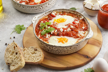 Traditional north african dish shakshouka made of eggs poached in a sauce of tomatoes, olive oil, bell peppers, onion and garlic, spiced with cumin, paprika and cayenne pepper