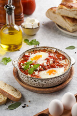 Traditional north african dish shakshouka made of eggs poached in a sauce of tomatoes, olive oil, bell peppers, onion and garlic, spiced with cumin, paprika and cayenne pepper