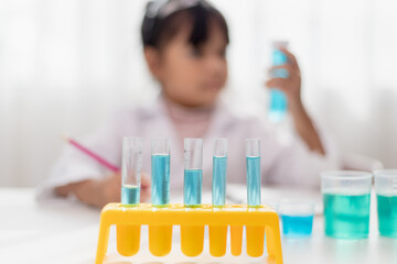 education, science, chemistry and children concept - kids or students with test tube making experiment at school laboratory