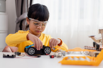Asia students learn at home in coding robot cars and electronic board cables in STEM, STEAM, mathematics engineering science technology computer code in robotics for kids concept.
