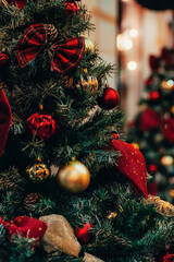Amazing Christmas decorations on fir tree with golden and red balls and Christmas lights, closeup