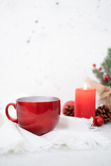 Obraz na płótnie Canvas Red winter tea cup on white napkin plus dusty concrete background - portrait