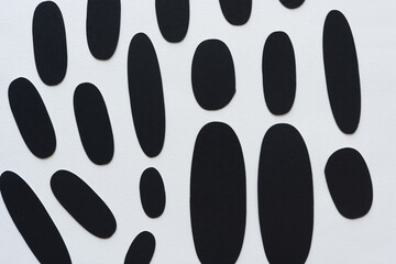 black paper ovals or shapes on blank paper