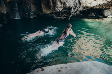 Kinder baden im Pool unter dem Ongongo Wasserfall, Warmquelle, Namibia