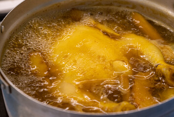 old asian cooking style concept, boiling chicken with yellow soup in pot.