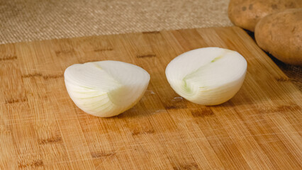 Peeling and cutting white onion on a cutting board. Vegetable soup recipe. Ingredients close-up