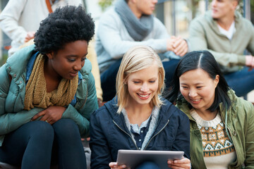 Look at this. Shot of a group of university students looking at something on a digital tablet.