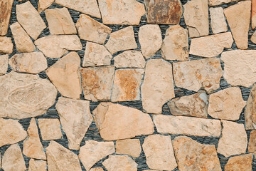 Beautiful yellow stone wall as background, closeup