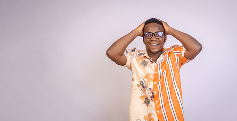 Amazed Excited young black African male smiling holding head with two hands